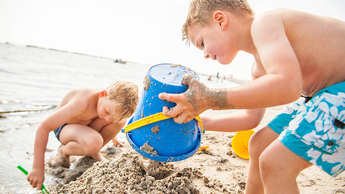 Kinder bauen eine Sandburg